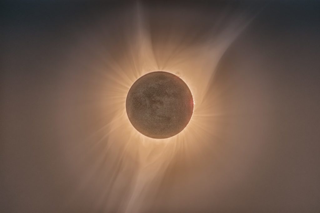 eclipse where we see the moon covering the sun with rays expanding beyond the middle circle